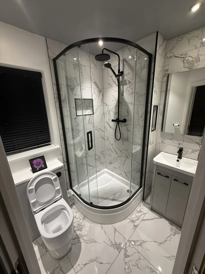 Ensuite with marble tiling and a black-frame shower